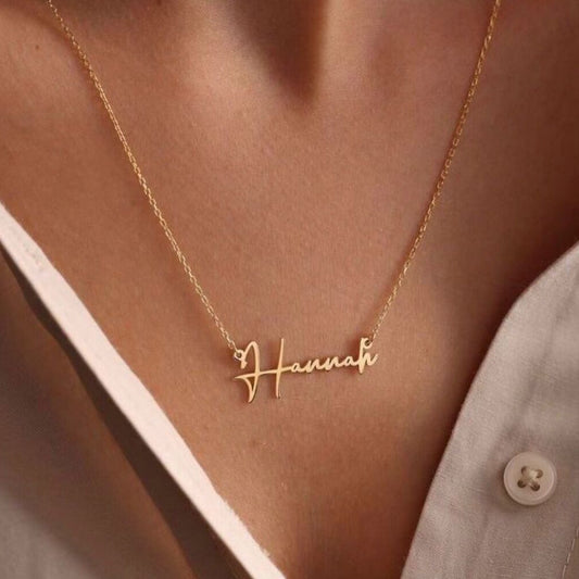 Gold custom name necklace reading “Hannah” worn on a woman’s neck